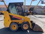 a yellow ski - loader parked in front of a building