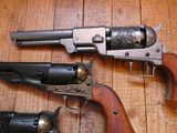 deux revolvers posés sur un plancher en bois, dont l'un sert d'arme