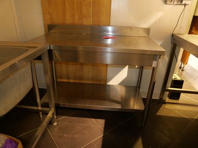 a stainless steel table in the middle of a kitchen