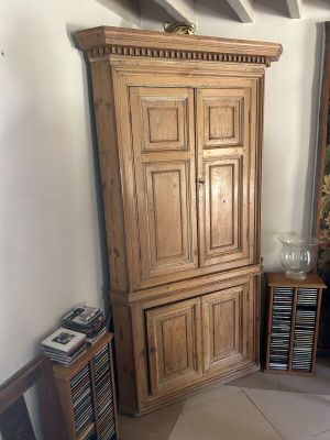 une grande armoire en bois dans un coin du salon