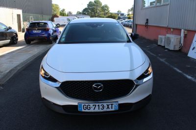 a white mazda vehicle parked on the side of the road