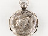 an antique silver pocket watch on a white surface with a white background