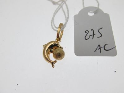 un petit pendentif en or auquel est accrochée une clochette, suspendu à son cou