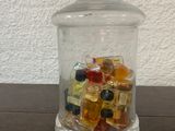 un bocal en verre rempli de bonbons assortis posé sur une table