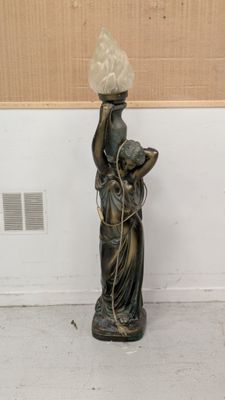 une statue représentant une femme tenant un panier sur la tête