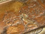 a bronze box with a picture of a man and a fish