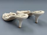 une paire de chaussures blanches à talons hauts ornées de nœuds sur la pointe