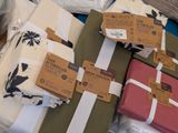 many wrapped presents on a table with tags on them