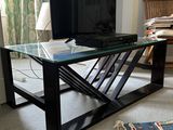 a glass coffee table with a television on it