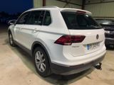 the rear end of a white volkswagen tigua parked in a garage