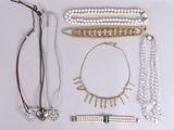 many different types of necklaces and bracelets laid out on a table