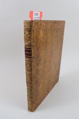 un vieux livre posé sur une table blanche, à côté d'un autocollant rouge