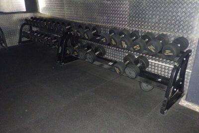 une photo d'une salle de sport avec un support à haltères