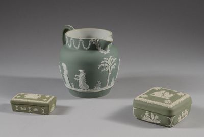 un vase vert et deux petites boîtes posées sur une table