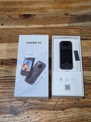 an open box of a cell phone sitting on top of a wooden table