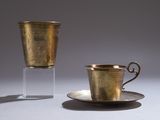 a cup and saucer sitting on a table next to each other