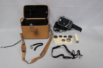 un étui marron contenant un appareil photo et d'autres objets, posé sur la table