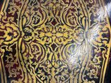 une table noire ornée d'un motif doré et rouge