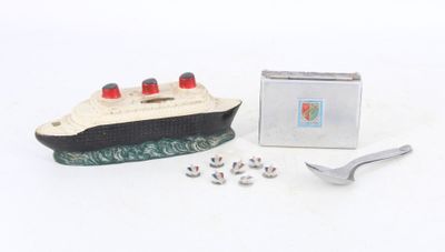 un petit bateau miniature avec une cuillère et un repose-cuillère à côté