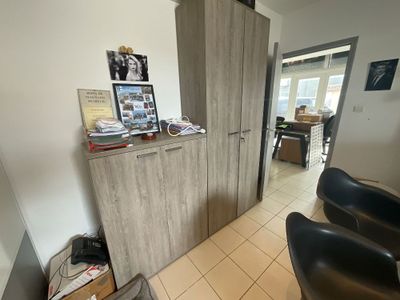 une pièce avec une chaise, une armoire et des tableaux accrochés au mur