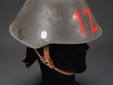 an old helmet with the number 12 painted on it on a mannequin head