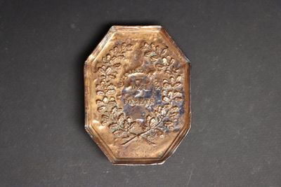 a small gold plate with a picture of a man on it