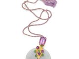 un gros plan d'un collier orné d'un pompon sur fond blanc
