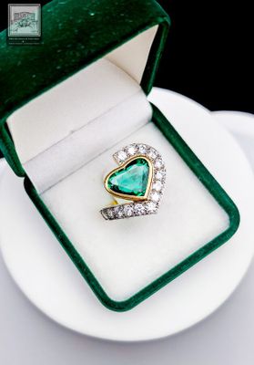 an image of a heart shaped emerald and diamond ring in a green velvet box