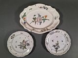 three plates with flowers on them on a table