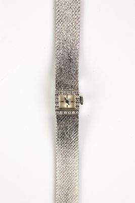 a close up of a watch on a white surface with a white background