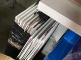 une pile de dossiers posée sur une étagère dans une pièce