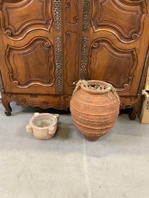 une grande armoire en bois à deux portes avec un vase