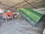 un camion-benne vert garé à l'intérieur d'un bâtiment
