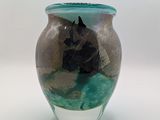 un vase en verre orné d'un cheval, posé sur une table
