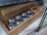 une boîte en bois remplie de clochettes en argent, exposée