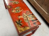 a red bench with a painting on it in a room