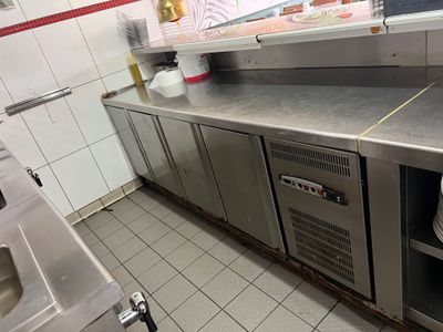 une cuisine avec des plans de travail en inox et un évier