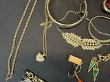 many different types of necklaces and bracelets laid out on a table