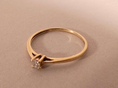 a picture of a gold ring with a diamond on it