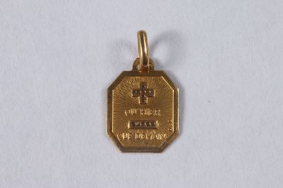 a small gold medal with a cross on it