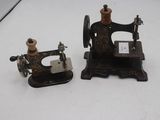 deux vieilles machines à coudre posées sur une surface blanche