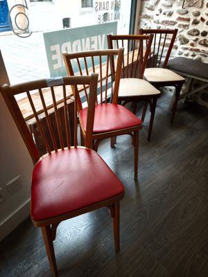 quatre chaises en bois alignées devant une fenêtre