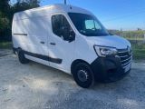 une camionnette blanche garée sur un parking en gravier, avec des arbres en arrière-plan