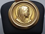 an image of a gold medal with a woman ' s face on it