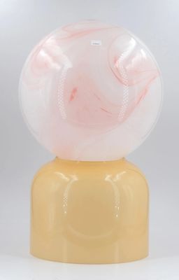 un gros plan d'un vase jaune surmonté d'une boule de marbre rose