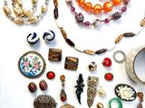 many different necklaces and bracelets laid out on a table