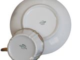 a white plate with a gold handle and a white plate with a gold handle