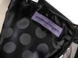 the back of a black and white polka dot suit with a purple label on it