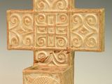 une petite croix en céramique ornée d'un motif décoratif