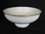 white bowl with gold rim on black background with black background